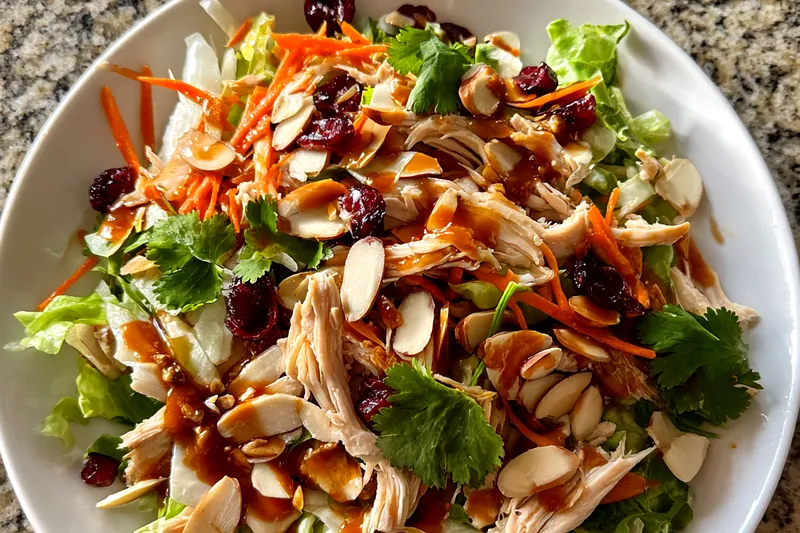 Fresh ingredients for Cranberry Chicken Salad Delight arranged on a wooden cutting board.