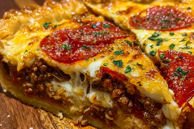 The cooking process of Savory Hamburger Pepperoni Pie Delight, showing the pie baking in the oven with golden cheese bubbling.