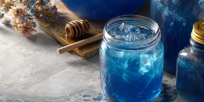 Bright blue festive punch with blueberries and mint garnish
