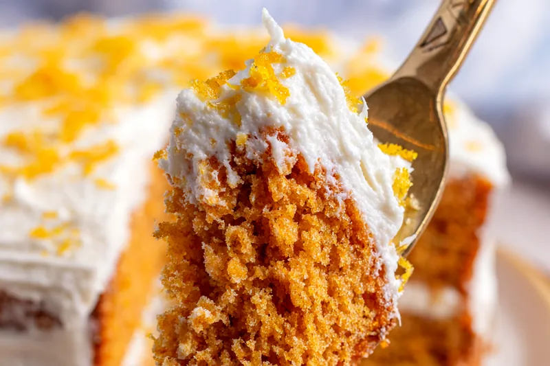 A close up of orange zest being rubbed into white sugar to release oils.