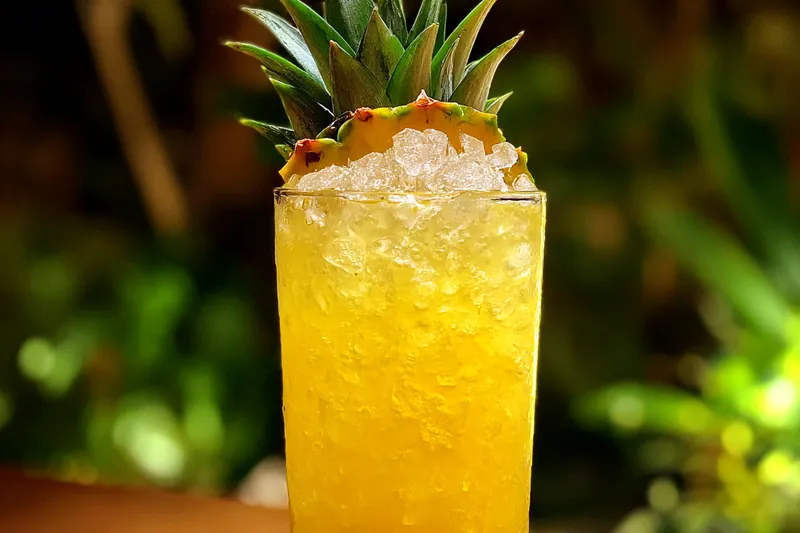 Fresh ingredients for making Refreshing Pineapple Coconut Drink, including pineapple, coconut milk, and lime.